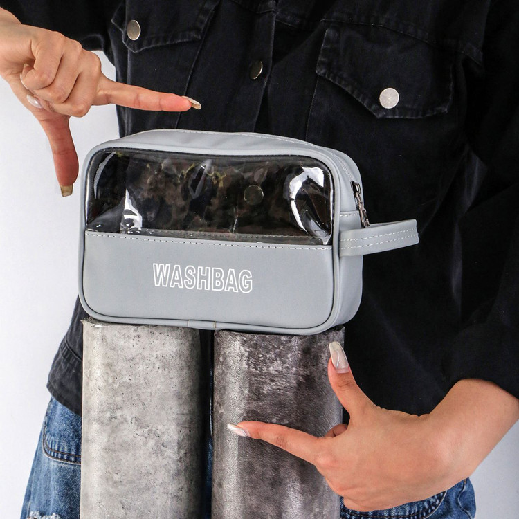 کیف شفاف طوسی با چاپ WASHBAG، دارای زیپ بالایی و مناسب نگهداری لوازم شخصی و بهداشتی