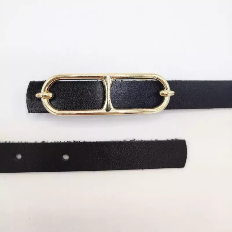 کمربند زنانه چرمی مشکی با عرض ۲ سانت و سگک طلایی بیضیشکل، مناسب استایلهای رسمی و مینیمال
