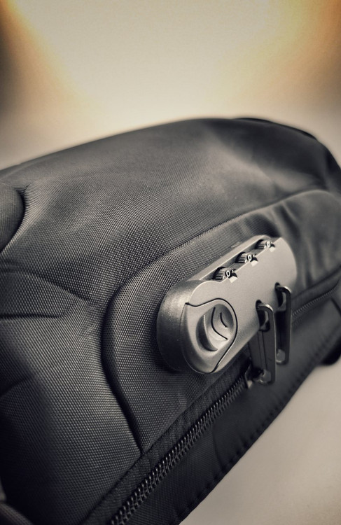 نمای نزدیک قفل رمزدار سهرقمی روی بادیبگ مشکی، مناسب حفظ امنیت وسایل شخصی