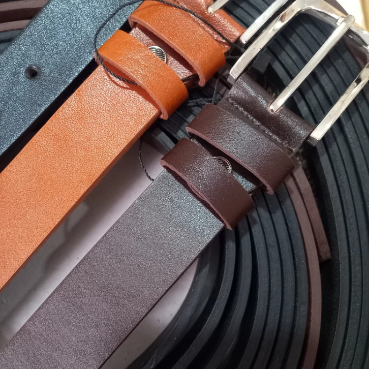 نمای نزدیک کمربندهای چرم طبیعی مردانه با سگک کلاسیک زبانه دار در رنگهای متنوع