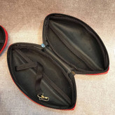 کیف آرایشی لبشکل قرمز با بدنه قالبی، فضای داخلی مشبک و کش نگهدارنده دائمی، چیدهشده روی سطح پارچهای