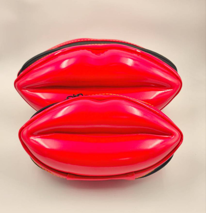 کیف آرایشی لبشکل در دو سایز بزرگ و کوچک، با طراحی قالبی قرمز براق و فضای داخلی مشبک، چیدهشده کنار هم برای نمایش تفاوت ابعاد